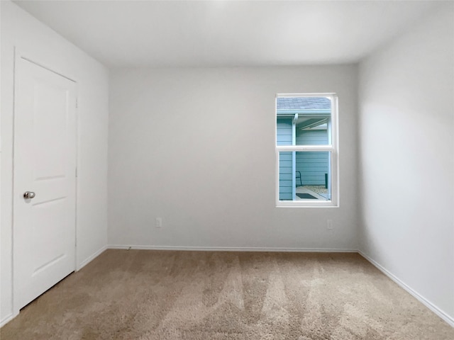 empty room with baseboards and carpet flooring