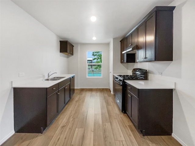 kitchen featuring light hardwood / wood-style floors, stainless steel dishwasher, sink, black range with gas stovetop, and dark brown cabinetry