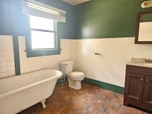 bathroom featuring vanity, toilet, tile walls, and a tub