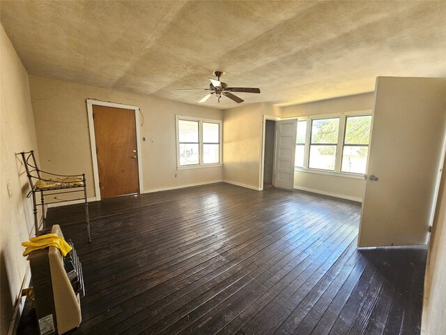 unfurnished living room with a textured ceiling, a wealth of natural light, hardwood / wood-style floors, and ceiling fan