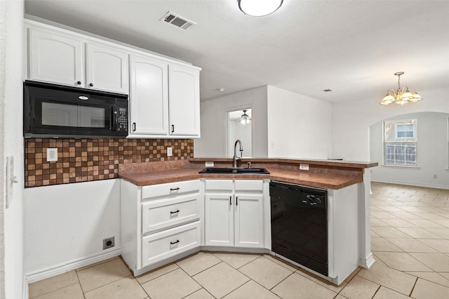 91 Pecan Dr, Pottsboro, TX 75076 - kitchen featuring black appliances, a peninsula, a sink, light tile patterned floors, and white cabinetry