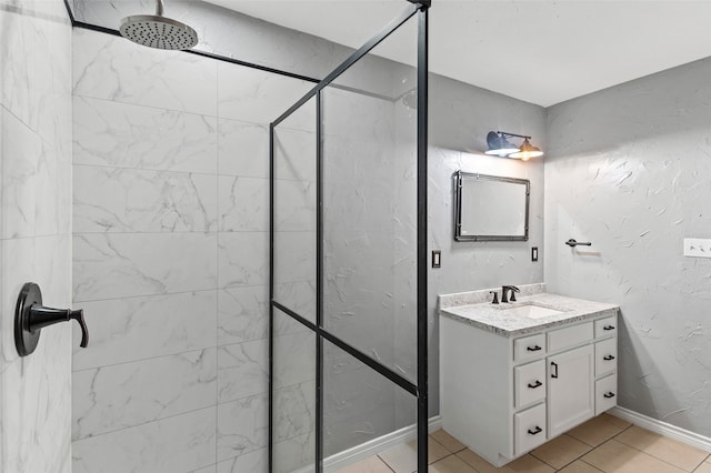 bathroom with vanity, a tile shower, and tile patterned floors