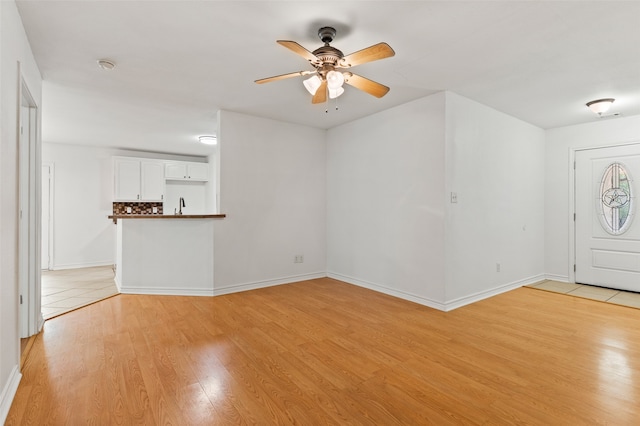 unfurnished living room with light hardwood / wood-style flooring and ceiling fan