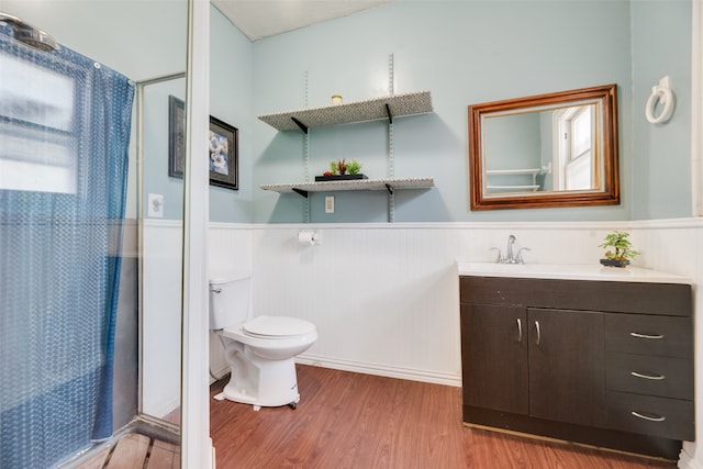 bathroom featuring toilet, walk in shower, vanity, wood-type flooring, and plenty of natural light