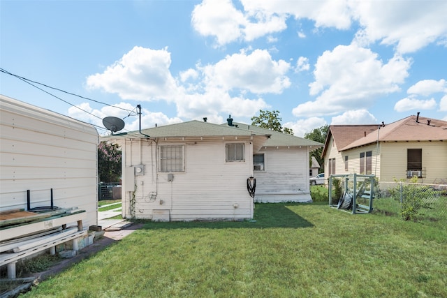 rear view of house featuring a yard