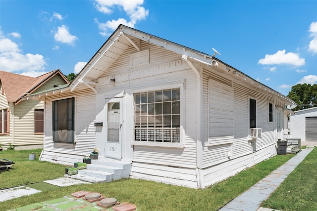 bungalow-style house featuring cooling unit and a front yard