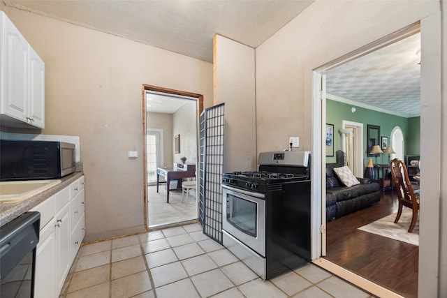 kitchen featuring crown molding, appliances with stainless steel finishes, light hardwood / wood-style floors, white cabinetry, and a textured ceiling