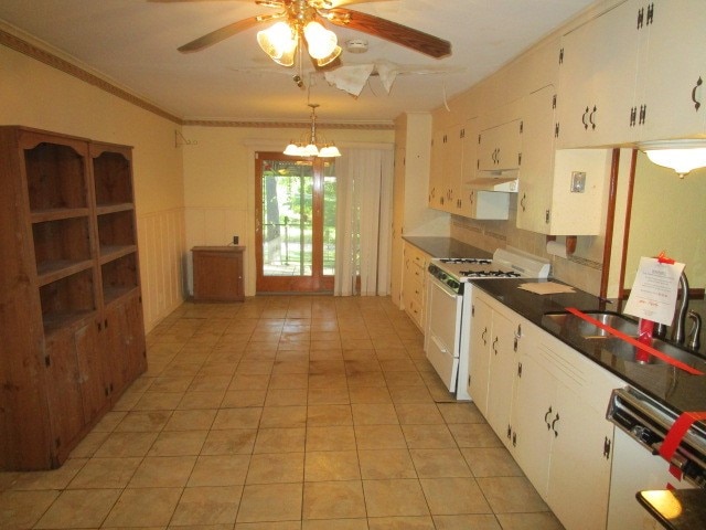 kitchen featuring ornamental molding, dishwashing machine, gas range gas stove, ceiling fan, and white cabinets