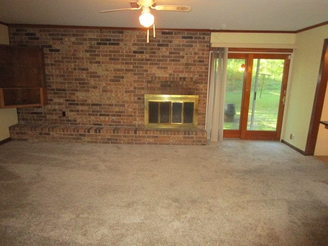 unfurnished living room with a fireplace, crown molding, ceiling fan, and carpet