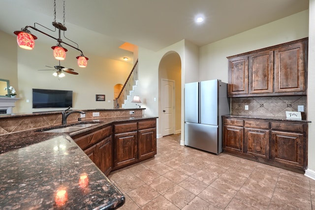 kitchen with dark brown cabinets, sink, stainless steel fridge, high vaulted ceiling, and ceiling fan