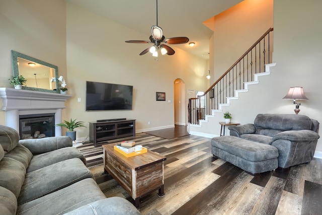 living room featuring ceiling fan, high vaulted ceiling, and dark hardwood / wood-style flooring