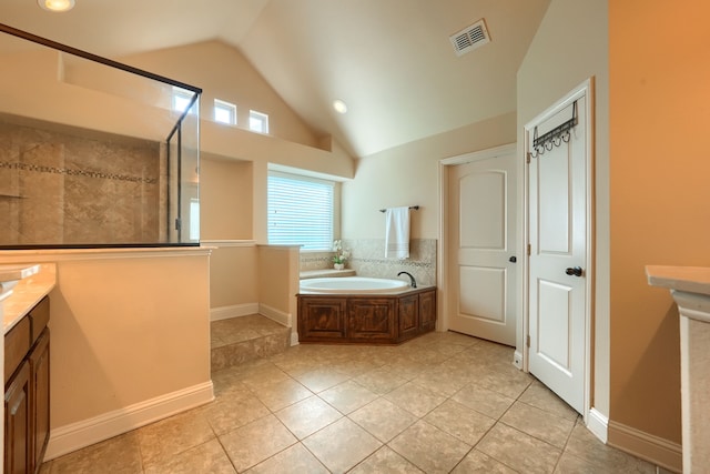 bathroom with vanity, tile patterned floors, vaulted ceiling, and a bath