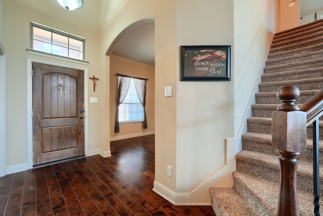 foyer entrance with ornamental molding, dark hardwood / wood-style floors, and a healthy amount of sunlight