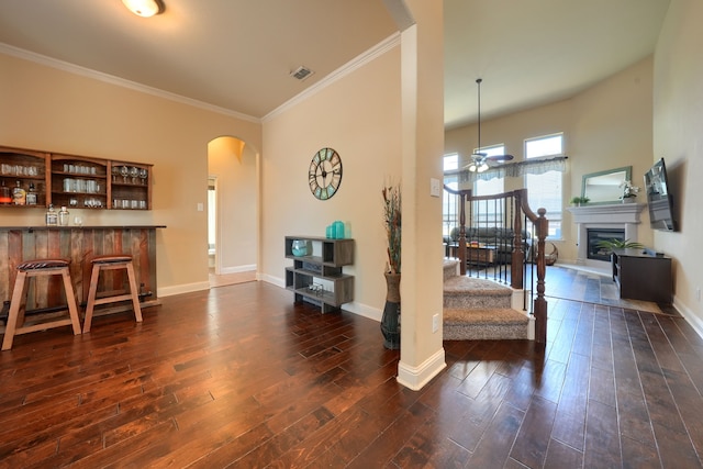 interior space with crown molding, ceiling fan, and dark hardwood / wood-style flooring