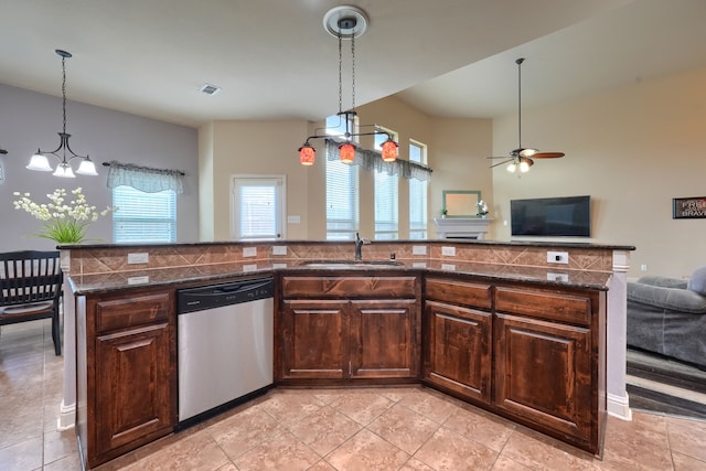 kitchen featuring hanging light fixtures, dark brown cabinets, a center island with sink, sink, and stainless steel dishwasher