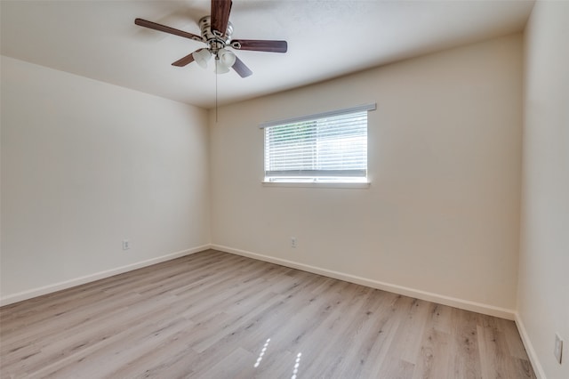 empty room with ceiling fan and light hardwood / wood-style flooring