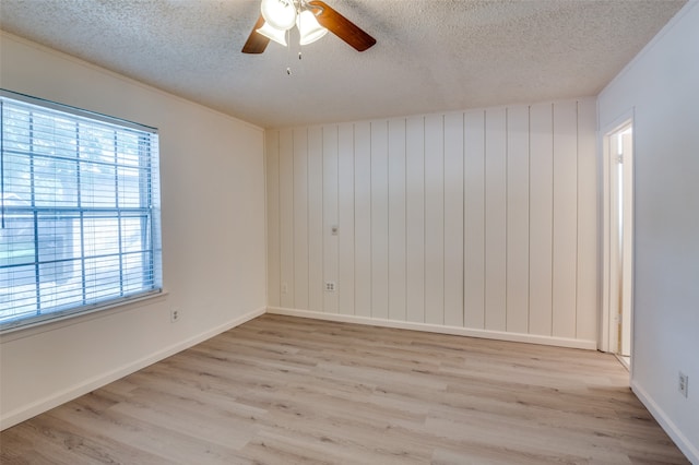 empty room featuring light wood-type flooring, a textured ceiling, and ceiling fan