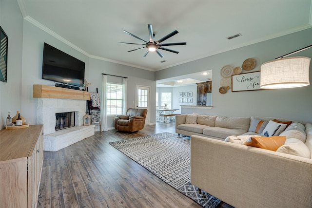 living room with ceiling fan, ornamental molding, and dark hardwood / wood-style floors