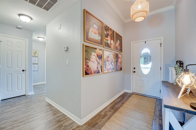 entrance foyer with crown molding and hardwood / wood-style flooring