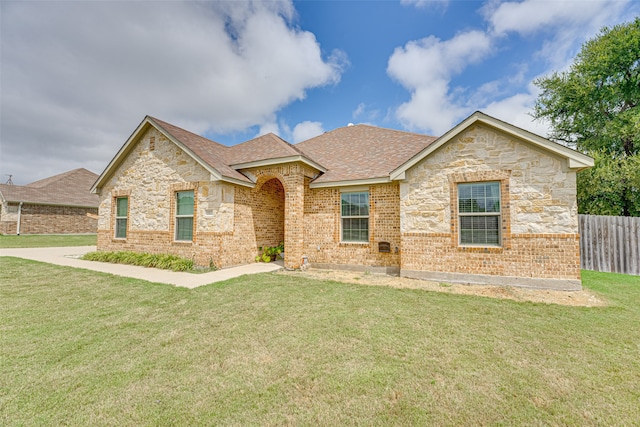 single story home featuring a front lawn