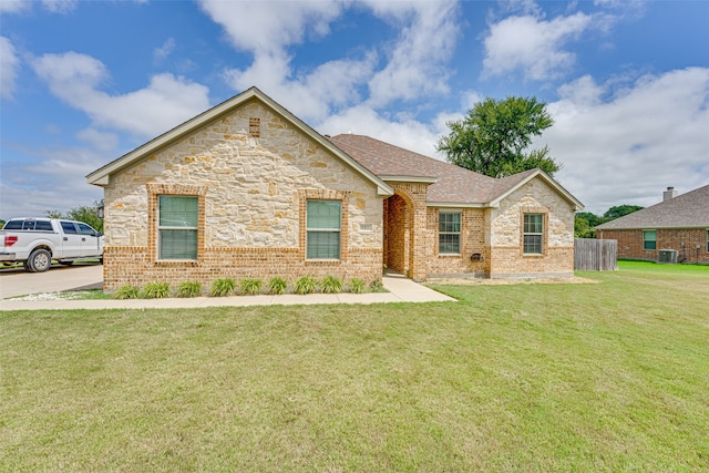 view of front of property with central AC unit and a front lawn