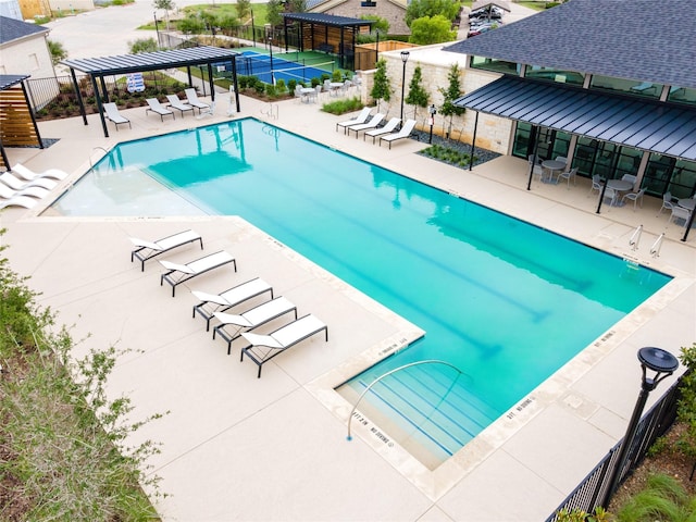 pool featuring fence and a patio area