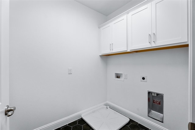 clothes washing area with cabinets, electric dryer hookup, hookup for a washing machine, and dark tile patterned floors