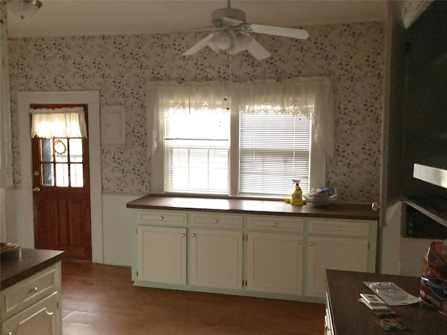 kitchen featuring hardwood / wood-style floors, ceiling fan, and white cabinetry