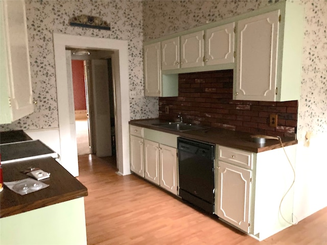 kitchen with decorative backsplash, black dishwasher, light hardwood / wood-style floors, and sink