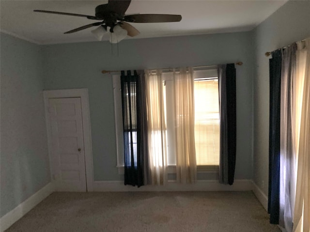 empty room featuring ceiling fan and light carpet