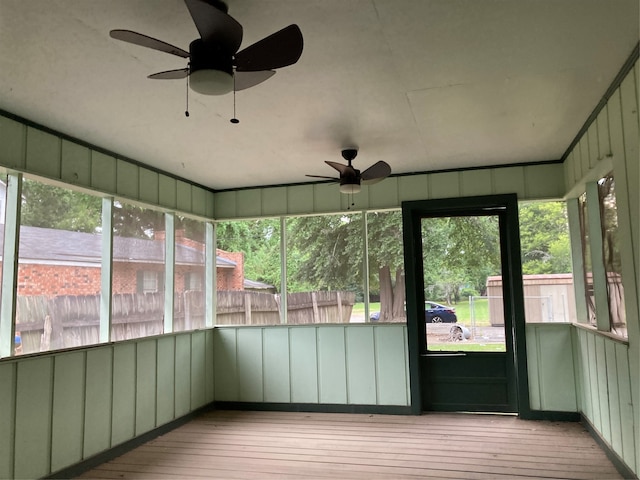 unfurnished sunroom featuring ceiling fan