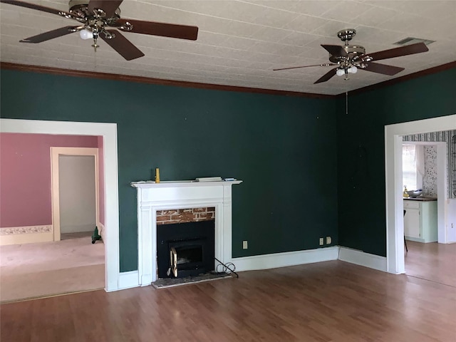 unfurnished living room with ceiling fan, ornamental molding, hardwood / wood-style flooring, and a fireplace