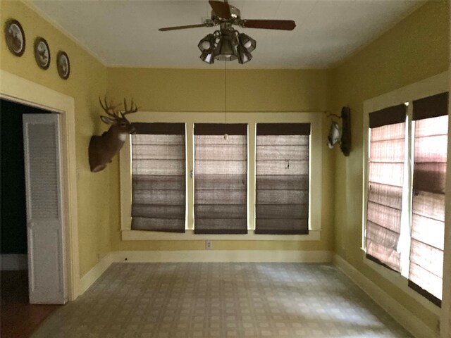 unfurnished sunroom featuring ceiling fan