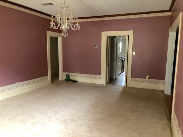 unfurnished dining area featuring ornamental molding, an inviting chandelier, and carpet floors