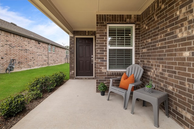 property entrance featuring a patio area and a yard