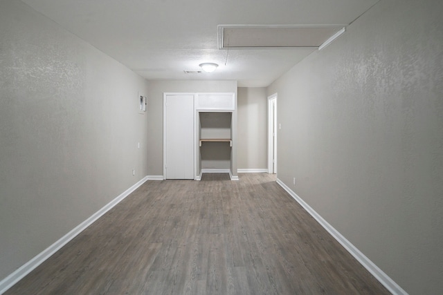 unfurnished bedroom featuring a textured ceiling and dark hardwood / wood-style floors