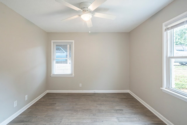 spare room featuring a healthy amount of sunlight, ceiling fan, and hardwood / wood-style floors