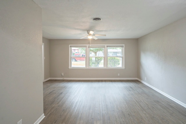 unfurnished room with a textured ceiling, wood-type flooring, and ceiling fan