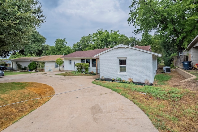 single story home featuring cooling unit and a garage