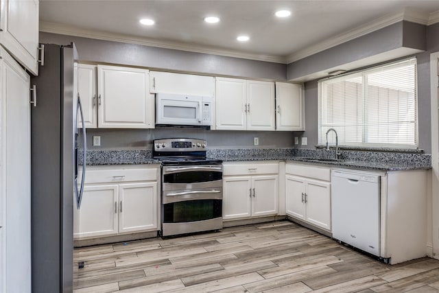 kitchen featuring stainless steel appliances, white cabinetry, and crown molding