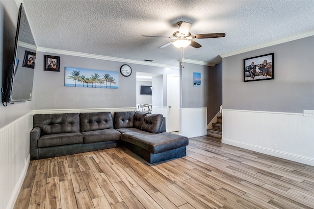 living room with a textured ceiling, light hardwood / wood-style floors, and ceiling fan