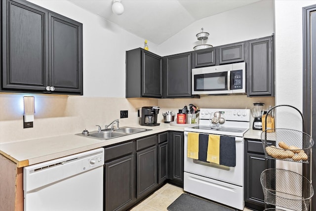 kitchen with vaulted ceiling, white appliances, light tile patterned floors, and sink