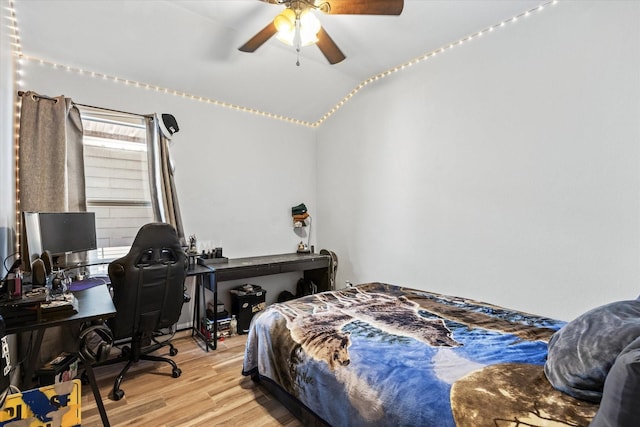 bedroom featuring light wood-type flooring, vaulted ceiling, and ceiling fan