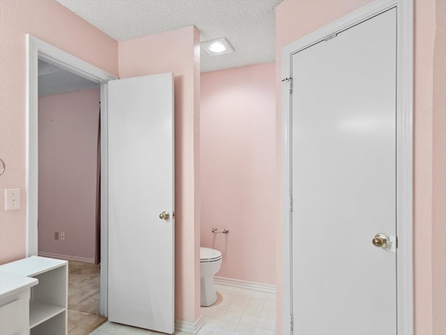 bathroom featuring a textured ceiling and toilet