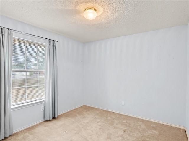 carpeted spare room with a textured ceiling