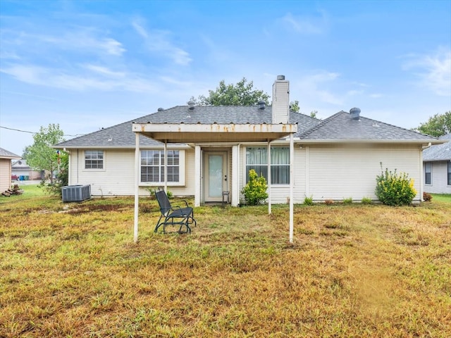 back of house featuring a lawn and central AC unit