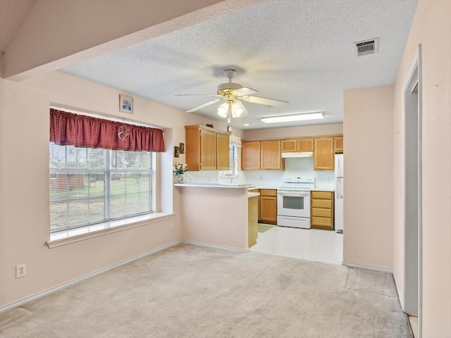 kitchen with a textured ceiling, ceiling fan, white appliances, and kitchen peninsula