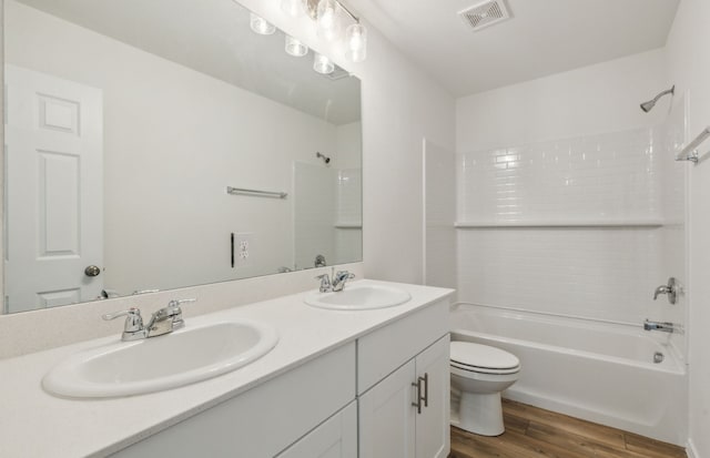 full bathroom featuring hardwood / wood-style flooring, vanity, toilet, and shower / bathing tub combination