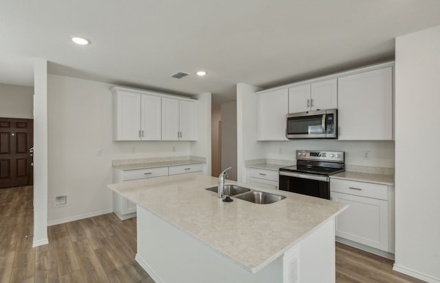 kitchen with sink, white cabinetry, stainless steel appliances, and an island with sink