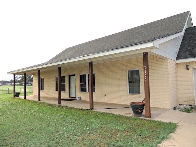 back of house featuring a lawn and a patio area